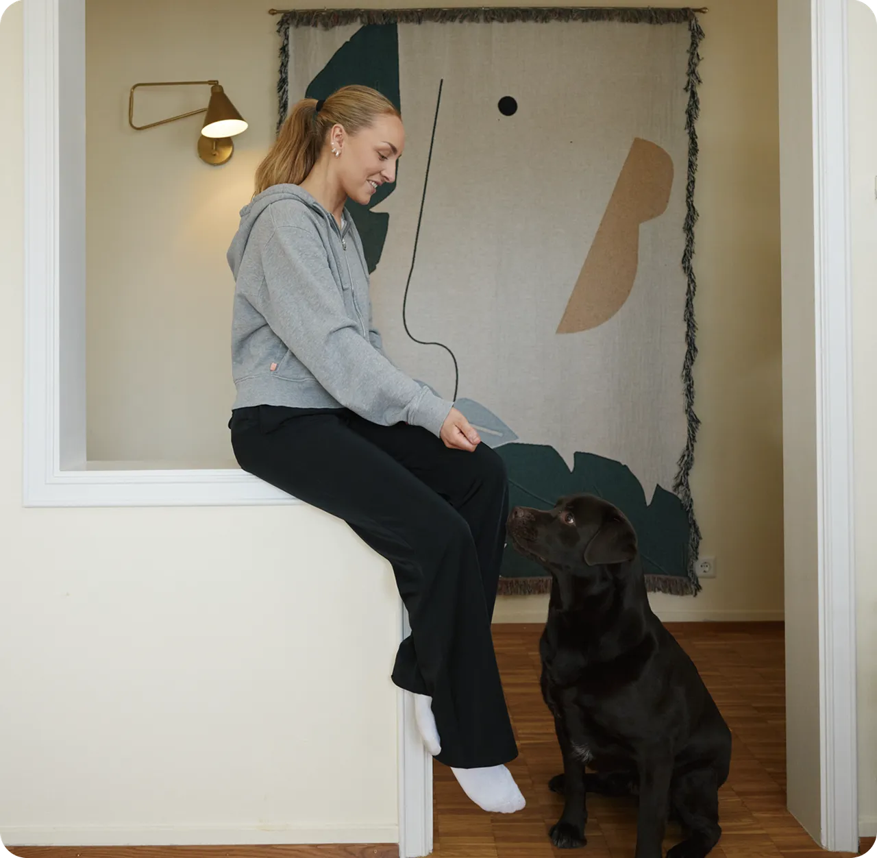 Someone sits smiling down at a dog